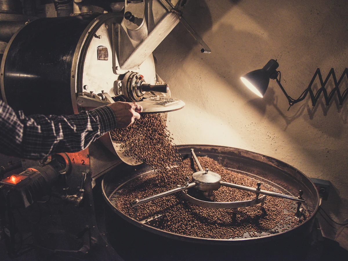 Freshly roasted beans pouring into the cooling tray of a coffee roaster